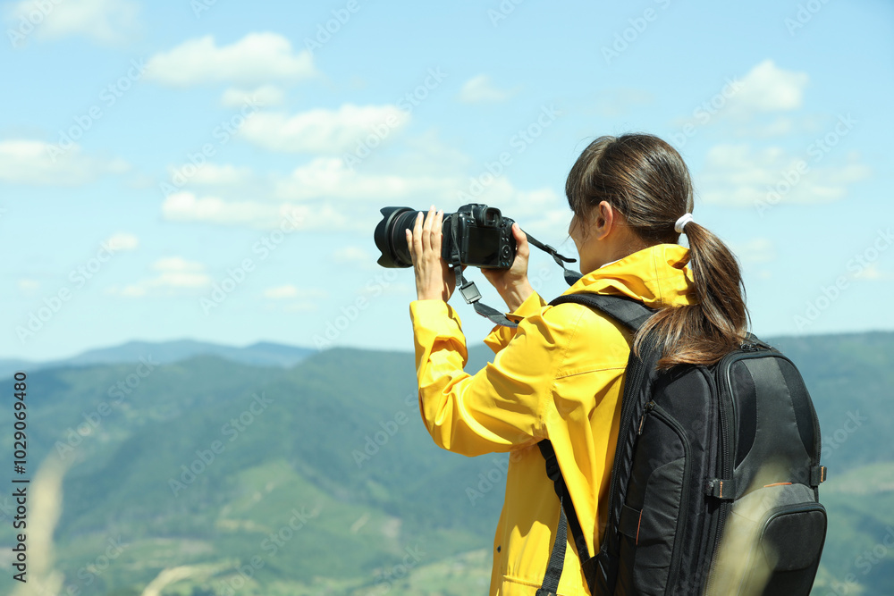 Photographer with backpack and camera taking picture of beautiful mountains Photographer with backpack and camera taking picture of beautiful mountains