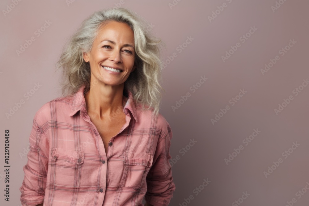 Portrait of a blissful woman in her 40s wearing a comfy flannel shirt on pastel gray background Portrait of a blissful woman in her 40s wearing a comfy flannel shirt on pastel gray background