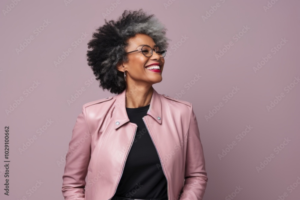 Portrait of a glad afro-american woman in her 40s sporting a stylish leather blazer over pastel gray background Portrait of a glad afro-american woman in her 40s sporting a stylish leather blazer over pastel gray background