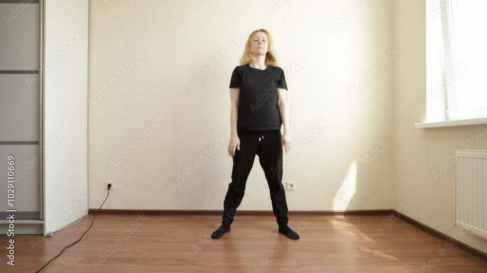 Woman dancing at home, practicing with an online dance instructor, focused on education and fun. Woman dancing at home, practicing with an online dance instructor, focused on education and fun.