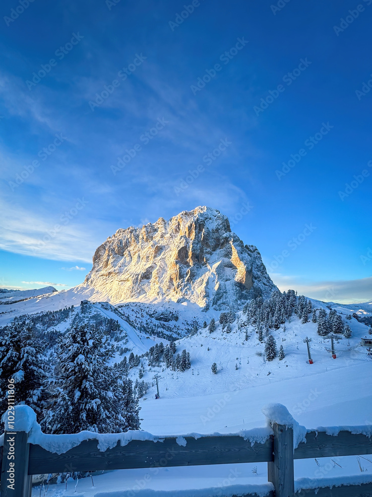 Langkofel mountain in South Tyrol, Italy covered with snow at sunrise against blue sky