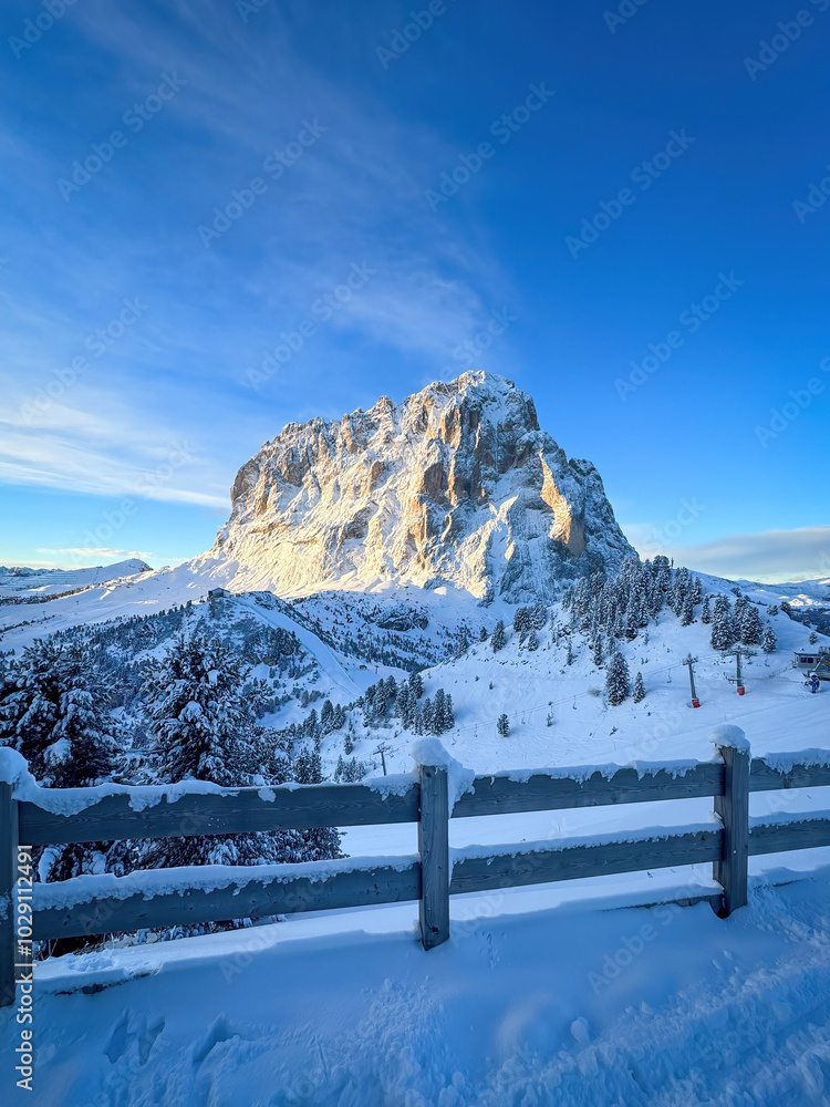 Langkofel mountain in South Tyrol, Italy covered with snow at sunrise against blue sky