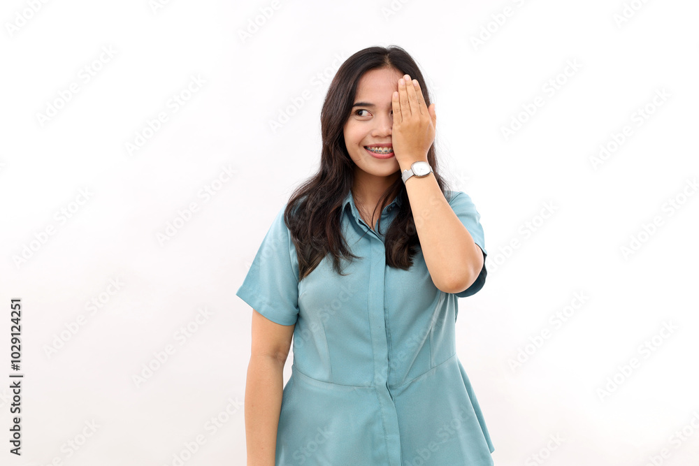 Young Asian woman covers eyes with hand hides face smiles pleasantly. Glancing to sideways. Isolated on white Young Asian woman covers eyes with hand hides face smiles pleasantly. Glancing to sideways. Isolated on white