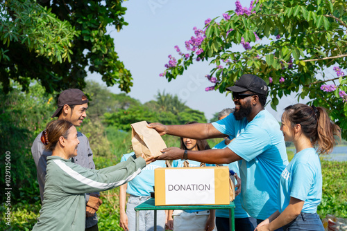 Photos volunteers giving paper bag of food to asian senior woman and son,group of volun