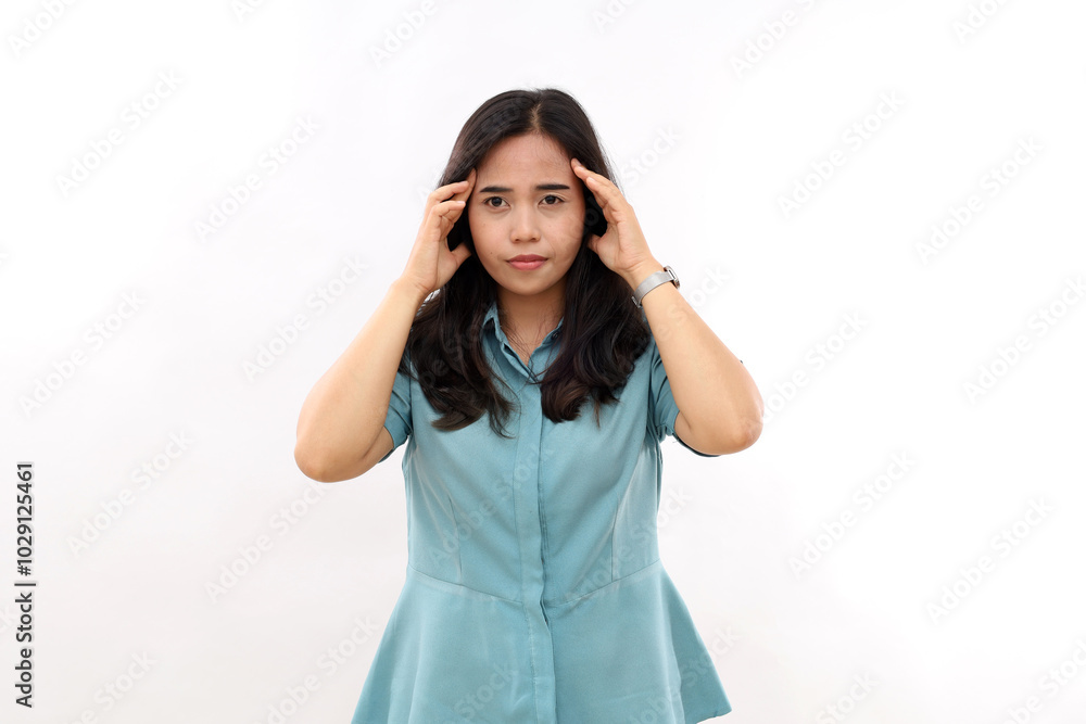 Stressful asian woman keeps fingers on temples, suffers from headache, has painful cramps, looks unhappily at camera, has dark hair, wears casual outfit, isolated on white background, feels tired Stressful asian woman keeps fingers on temples, suffers from headache, has painful cramps, looks unhappily at camera, has dark hair, wears casual outfit, isolated on white background, feels tired