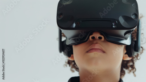 Immersed in virtual world, young boy experiences excitement of technology through VR headset. His focused expression reflects curiosity and wonder