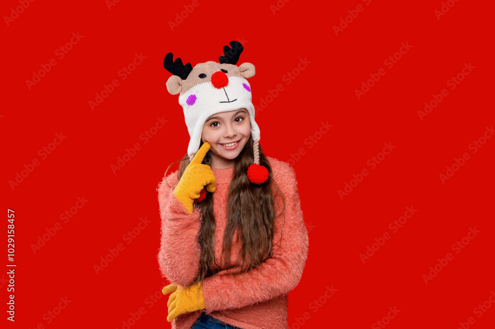 Girl in knitted hat in winter season. Childhood lifestyle. Winter child wardrobe. Teenage girl in Xmas hat isolated on red. Winter fashion for teenage style. Earflap tassels Girl in knitted hat in winter season. Childhood lifestyle. Winter child wardrobe. Teenage girl in Xmas hat isolated on red. Winter fashion for teenage style. Earflap tassels