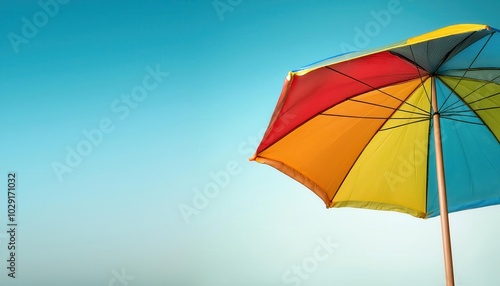 Bright and Colorful Rainbow Beach Umbrella with Vibrant Multicolor Panels Set Against a Clear Blue Sky. Ideal for Summer Vacation Ads, Resort Promotions, Tropical Getaways, and Outdoor Leisure Concep