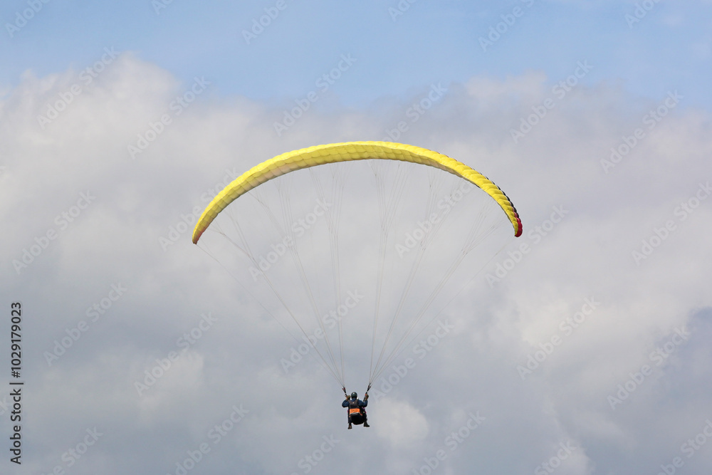 Tandem Paraglider flying in a cloudy sky Tandem Paraglider flying in a cloudy sky