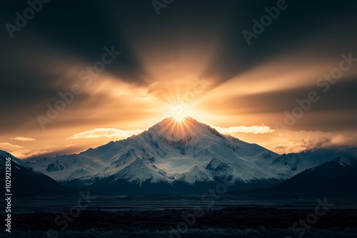 A majestic mountain peak glows with the light of the rising sun.