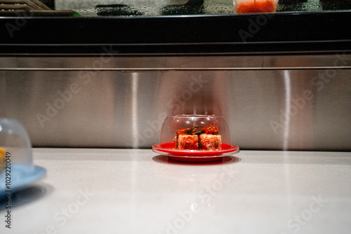 various types of sushi on conveyor belt in a Japanese restaurant. Shushi Go Round is a famous form of fast food in Asia, also known as sushi train. photo