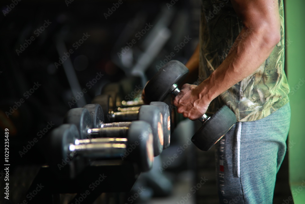 Naklejka premium Fitness and healthy background concept. Dumbbells with blurred gym or sport club background at sunset. Picture for add text message. Backdrop for design art work.