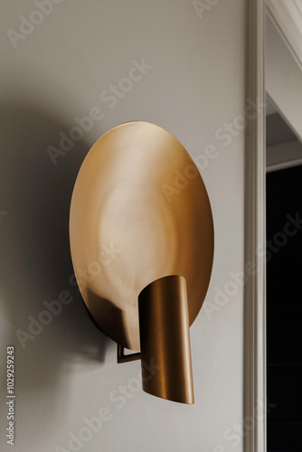 Modern Gold Wall Sconce With A Circular Disc Design. photo