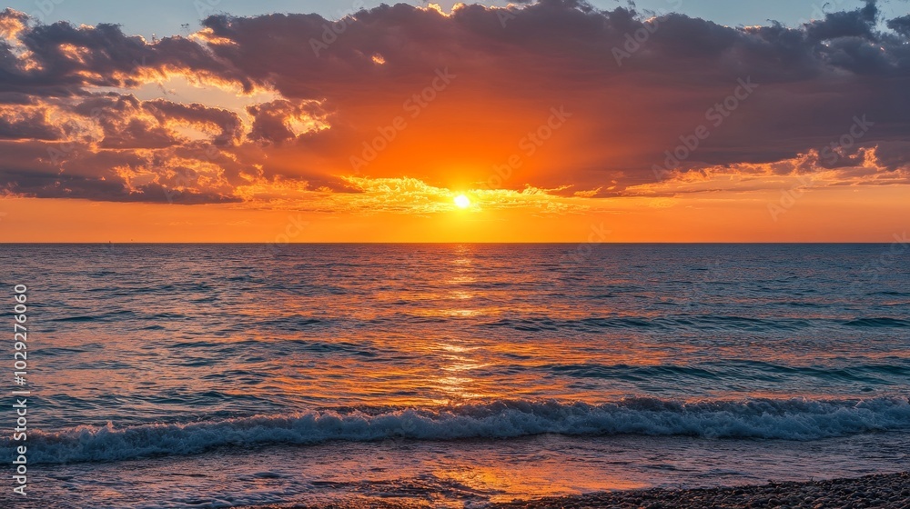 Fototapeta premium Beautiful sunset on the ocean shore with orange and pink clouds.