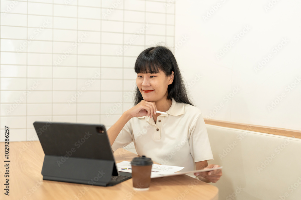 Businesswoman smiling and working with documents and digital tablet at cafe Businesswoman smiling and working with documents and digital tablet at cafe