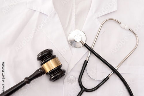 Obraz na płótnie Close up of a Doctor's White Lab Coat with Stethoscope and gavel, medical law or