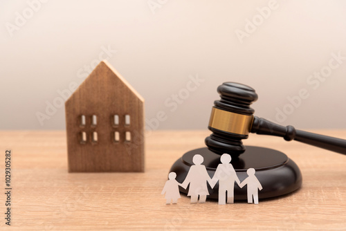 paper family cutout with gavel and wooden house model on wooden desk, Family law and heritage concept photo