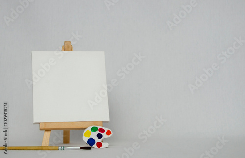 Mini easel with white blank canvas. Art concept. White background. photo