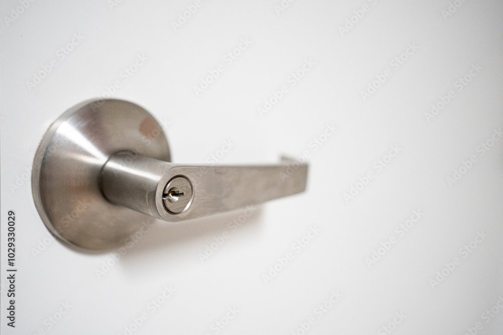 Closeup detail of metallic handle door lock on white door Closeup detail of metallic handle door lock on white door