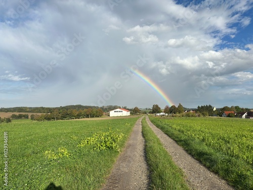 disappearing rainbow over the fields of a German village