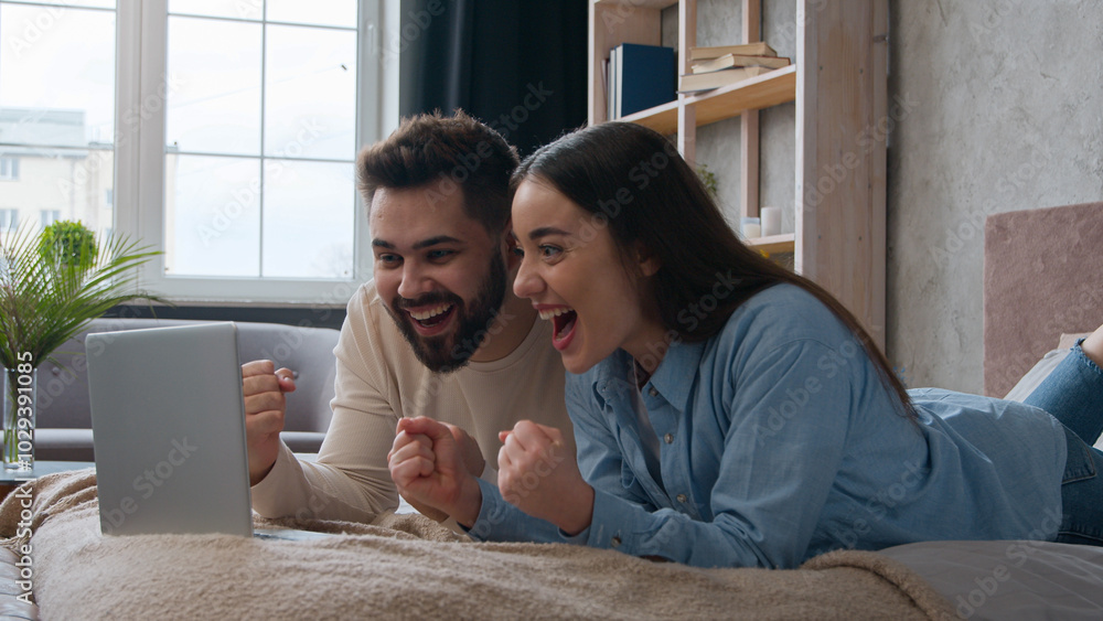 Excited Caucasian married couple lying on bed at home win laptop achievement read amazing news online bet victory celebrate success happy woman wife and man husband scream shout good result winning Excited Caucasian married couple lying on bed at home win laptop achievement read amazing news online bet victory celebrate success happy woman wife and man husband scream shout good result winning