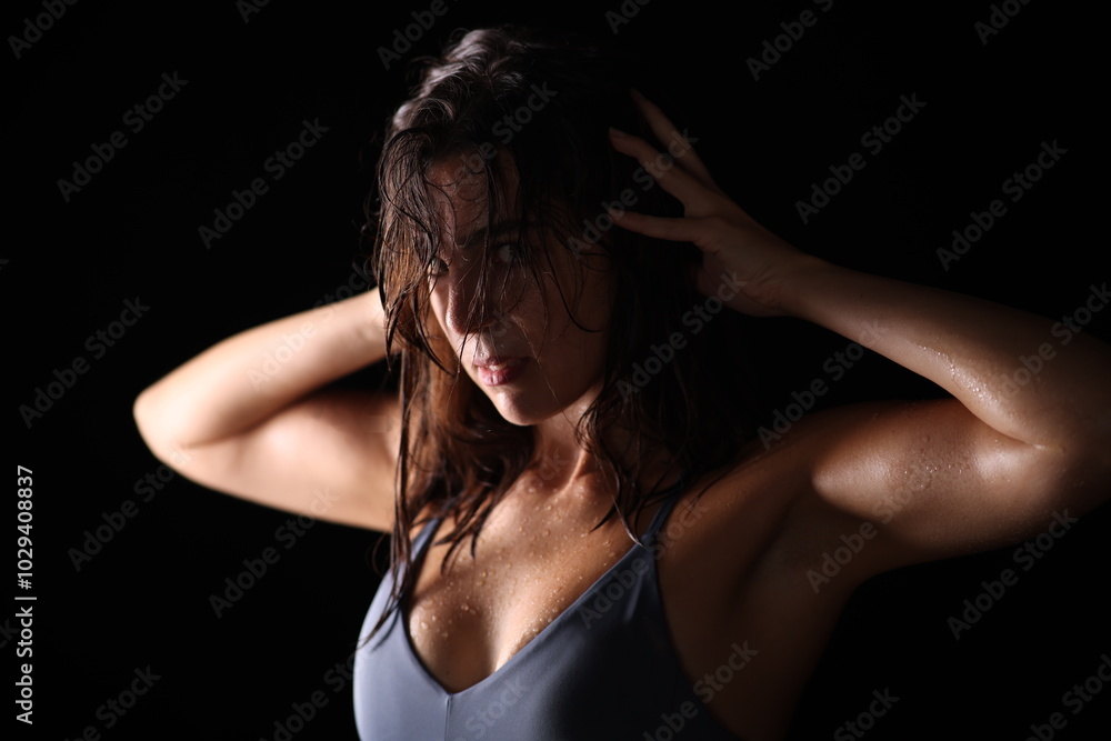 young woman in fitness outfit with wet hair hands on head young woman in fitness outfit with wet hair hands on head