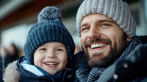 A heartwarming portrait of a father and son bundled up in cozy winter hats, both smiling brightly, capturing a moment of family warmth and togetherness.