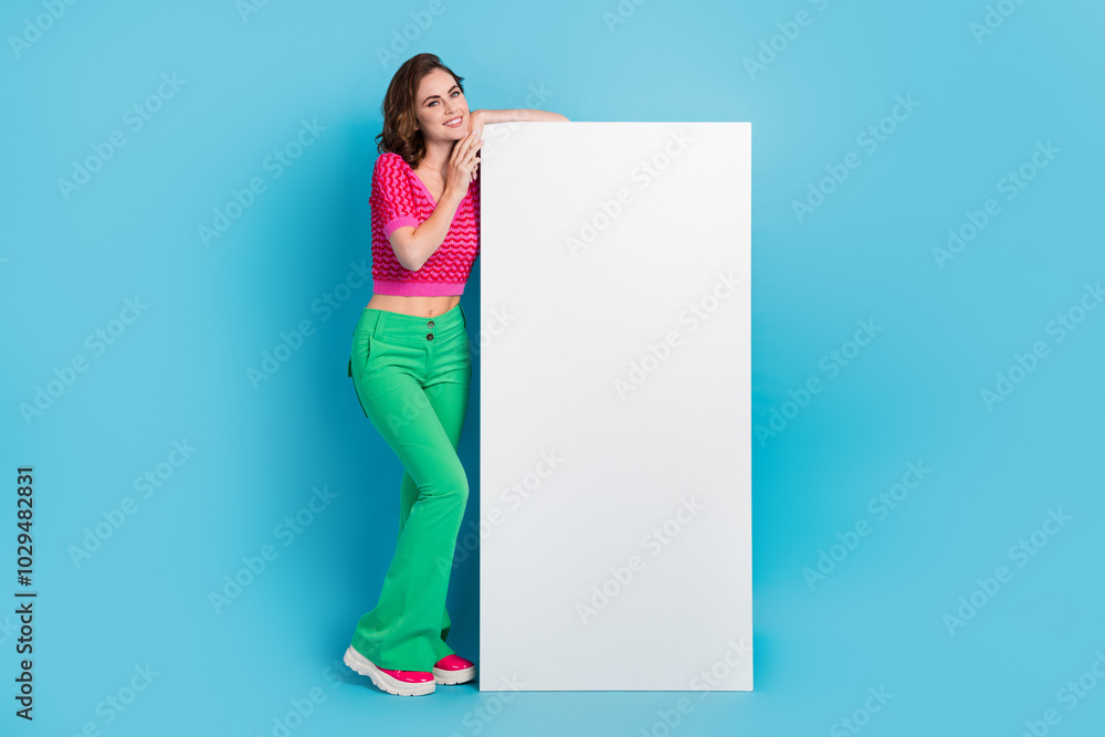 Full length photo of adorable lady wear trendy clothes presenting empty space modern technology shop isolated on blue color background Full length photo of adorable lady wear trendy clothes presenting empty space modern technology shop isolated on blue color background