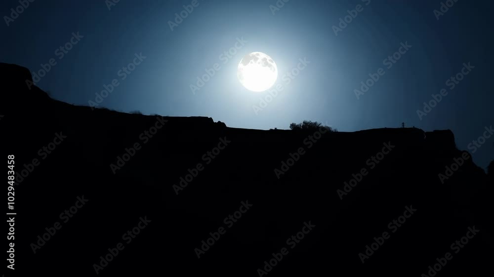 The full moon shines over dark mountains, casting a warm glow. The serene scene captures the beauty of nature at dusk, creating calm in the wilderness The full moon shines over dark mountains, casting a warm glow. The serene scene captures the beauty of nature at dusk, creating calm in the wilderness