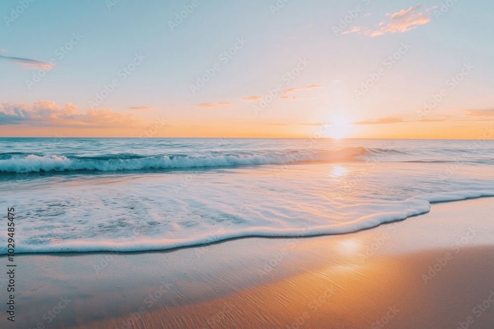 Fototapeta premium A serene early morning sunrise illuminating gentle ocean waves on a sandy beach.