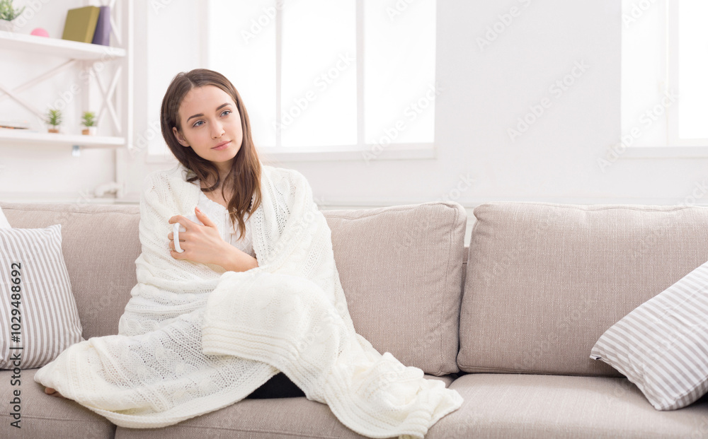 Young woman having a rest. Wrapped up in white blanket and drinking coffee in warm atmosphere, copy space Young woman having a rest. Wrapped up in white blanket and drinking coffee in warm atmosphere, copy space