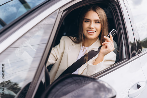 Confident Woman Smiling While Holding Car Key From Driver's Seat