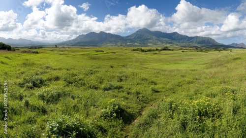 Tranquil spring panorama of lush green fields and majestic mountains for nature photography