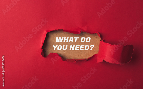 A red paper with a hole in it and the words What do you need written on it