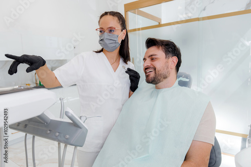 Dental consultation in a modern clinic with a dentist showing a patient the treatment plan