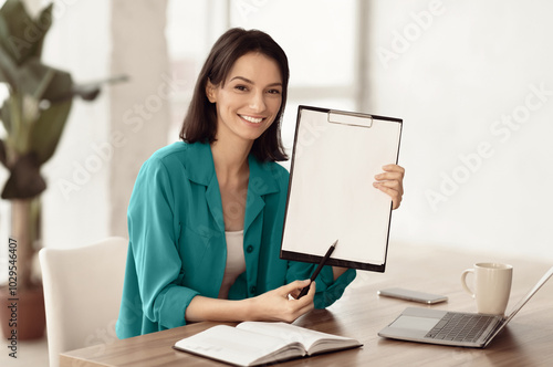 Doing Survey Research. Young woman showing clipboard paperholder working at office, copyspace photo