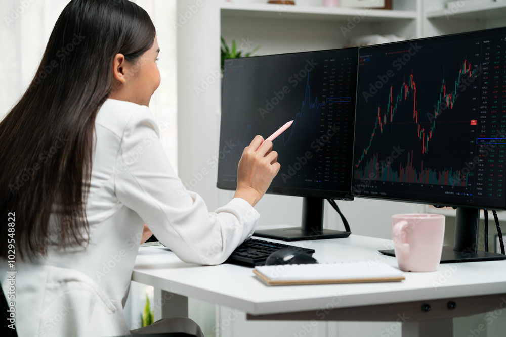 Young beautiful Asian businesswoman looking on pc to analyze profitable of exchange stock market graph at modern office. Concept of investing high profit in wealth security in finance. Stratagem. Young beautiful Asian businesswoman looking on pc to analyze profitable of exchange stock market graph at modern office. Concept of investing high profit in wealth security in finance. Stratagem.