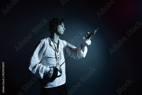 A dramatic hero with a sword in his hands, suffering from defeat and injury, a portrait in the moonlight, drama or theater photo