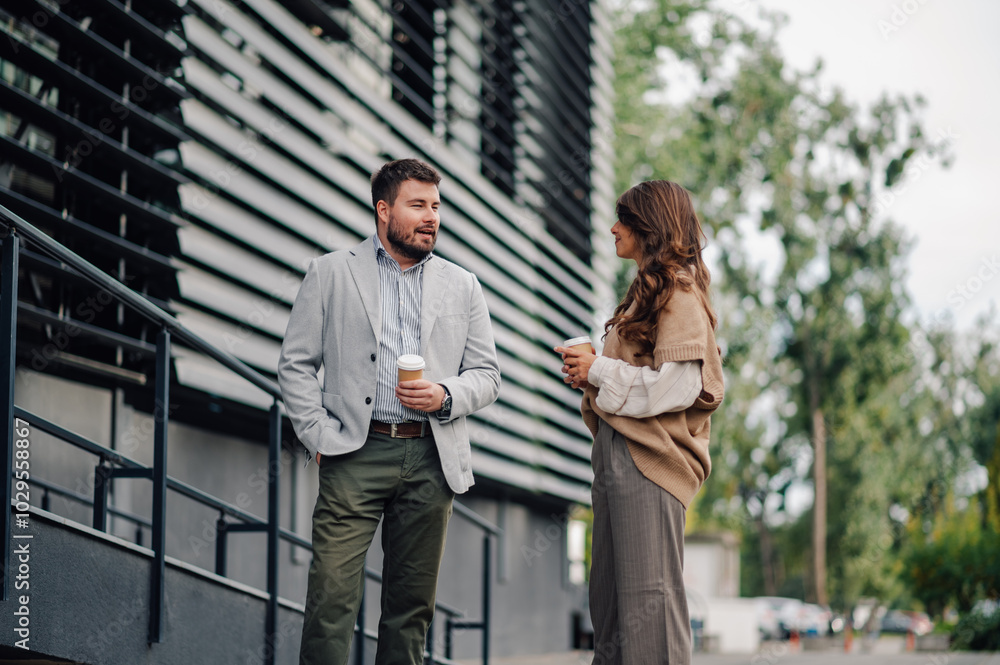 Business partners enjoying a coffee break outside the office building Business partners enjoying a coffee break outside the office building