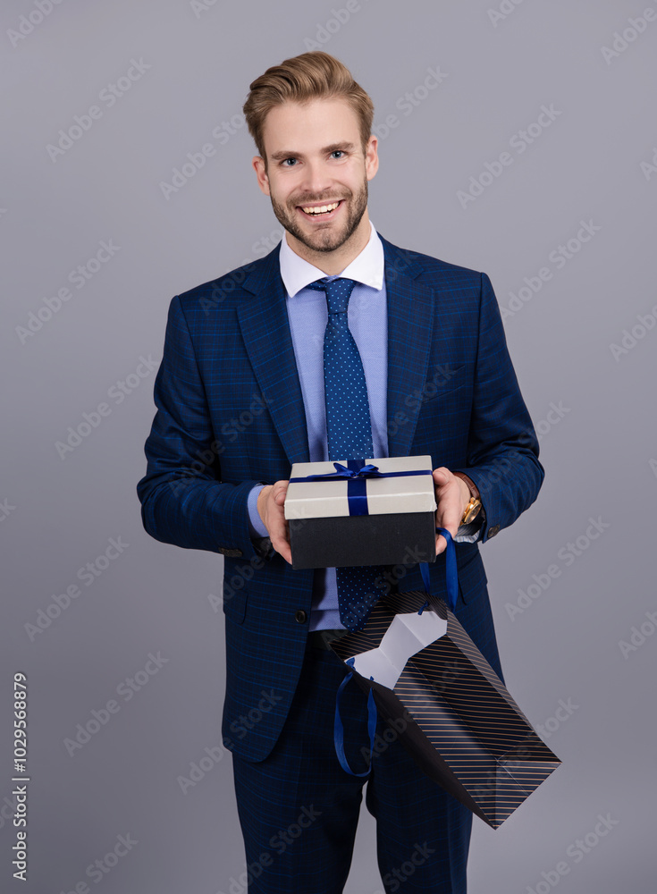 Successful boss hold gift. Anniversary. Businessman rewarded for good work. Secret valentine at business corporate. Business man with corporate gift isolated on grey. Corporate present. Mens day