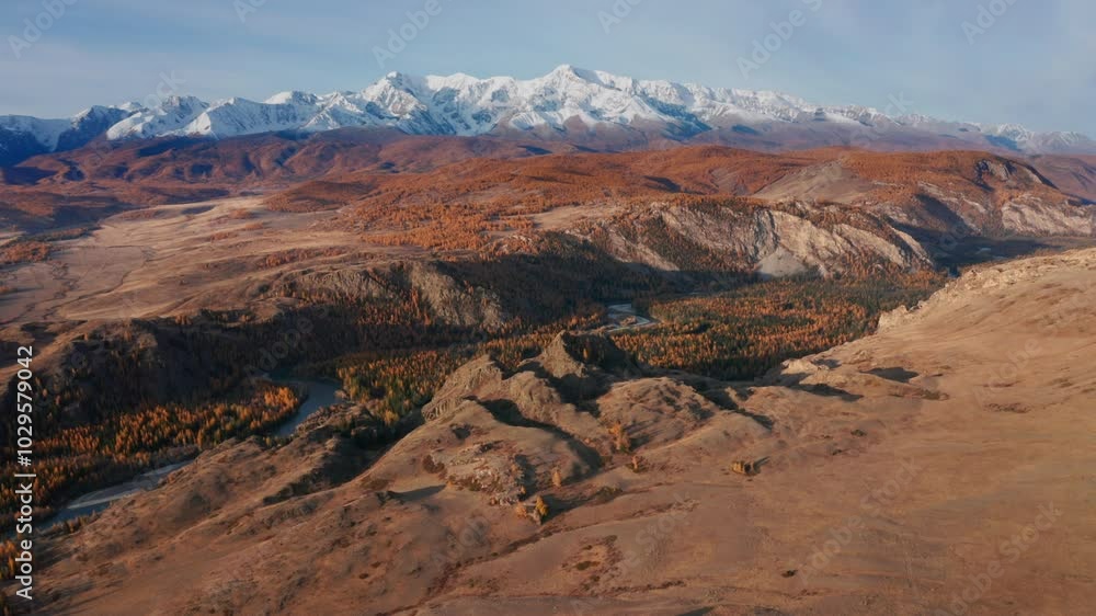 Experience a breathtaking aerial view of Mountain Altai in late autumn, captured by drone. The scene showcases a stunning autumnal landscape with majestic snow-covered peaks and a winding river below. Experience a breathtaking aerial view of Mountain Altai in late autumn, captured by drone. The scene showcases a stunning autumnal landscape with majestic snow-covered peaks and a winding river below.
