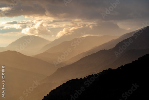 Sunset in the mountains on the island of Crete, Greece. The hills fade into the distance with a gradient.