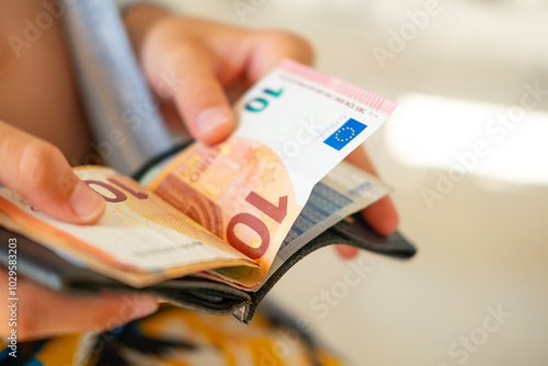 Tableau sur toile Teen holding wallet with Euro bills, symbolizing pocket money, savings or planni
