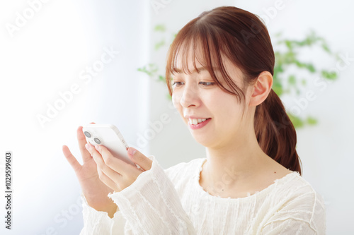 スマホを操作する笑顔の女性