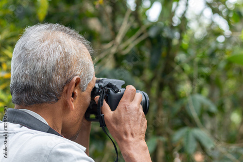 Senior nature photographer on mountain - professional photographer taking photos of nature in the forest