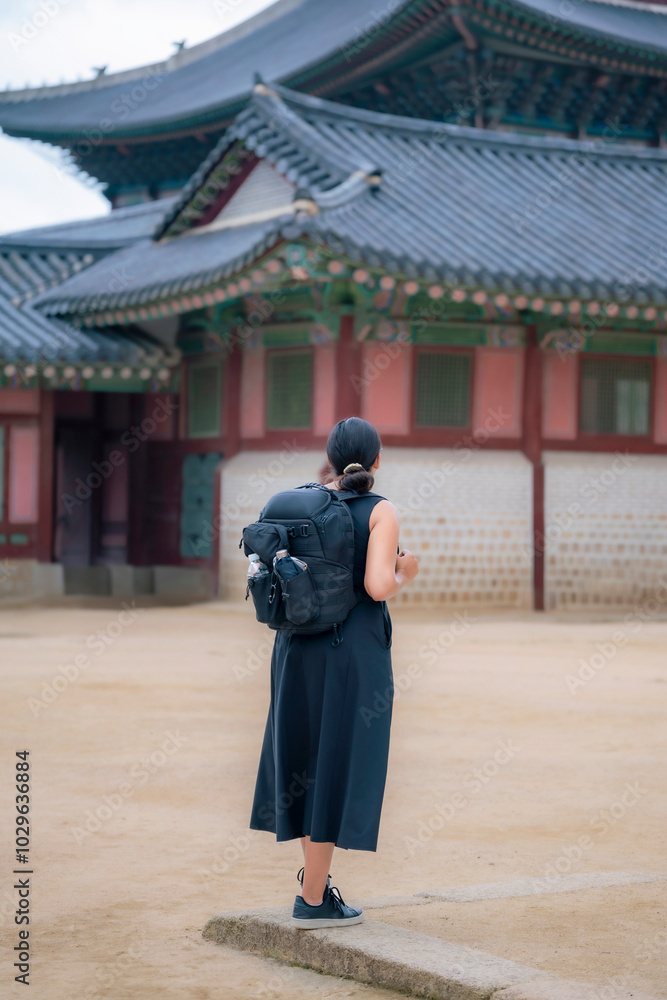 Unrecognizable young happy Latina woman smiling in Seoul temple courtyard in Gyeongbokgung Palace, South Korea. Unrecognizable young happy Latina woman smiling in Seoul temple courtyard in Gyeongbokgung Palace, South Korea.