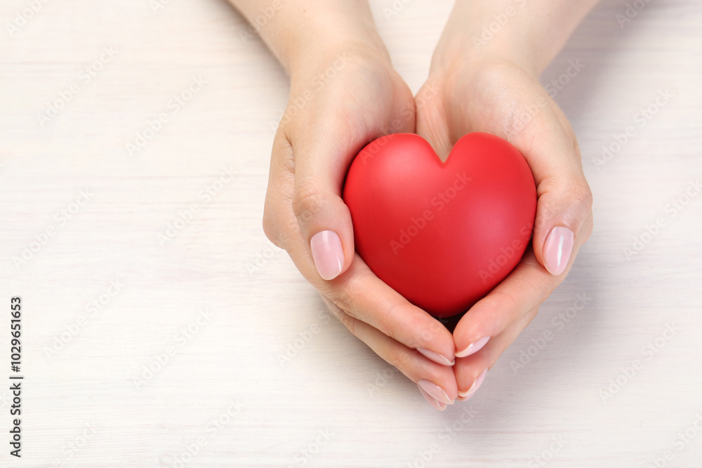 Woman with red decorative heart at white wooden table, closeup. Space for text Woman with red decorative heart at white wooden table, closeup. Space for text