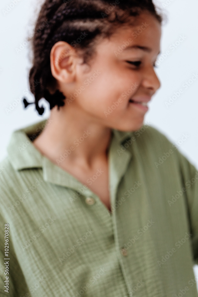 Joyful young boy with green shirt and braids exuding trendy style and confidence Joyful young boy with green shirt and braids exuding trendy style and confidence