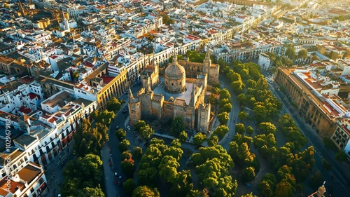 An aerial view of Seville, Spain, showcasing the city's historic architecture and vibrant green spaces during a sunny morning