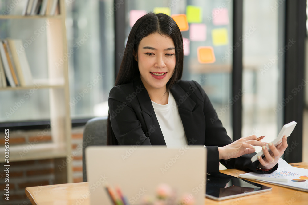 Asian business woman Use a calculator or laptop to make an accounting of income and expenses. Monthly expenses Asian business woman Use a calculator or laptop to make an accounting of income and expenses. Monthly expenses